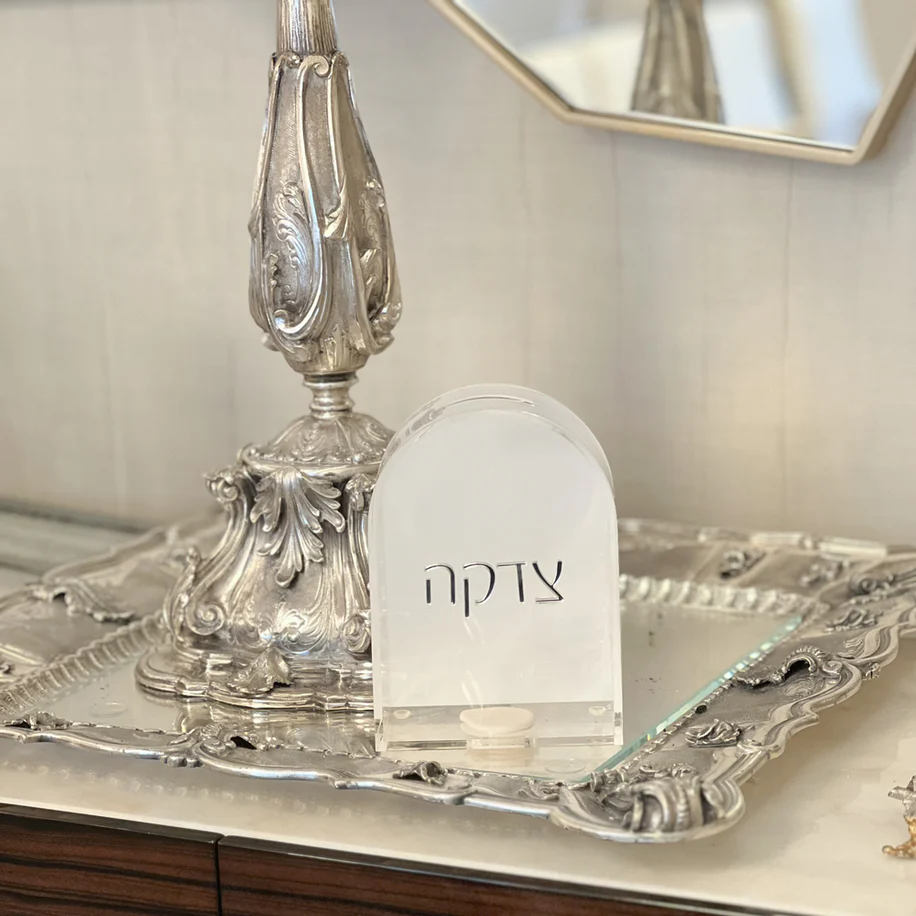 Lucite tzedakah box with silver writing 